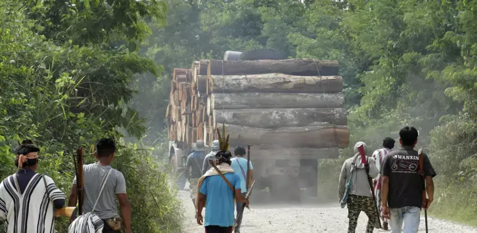 Hombres indígenas Ashaninka, armados con escopetas y arcos y flechas, obligan a un camión de carga de madera cortada en la Amazonia, a darse la vuelta ante el bloque de la carretera impuesto como protesta por la muerte del líder Ashaninka Santiago Contoricón, de 57 años, en Puerto Ocopa, Perú, el sábado 15 de abril de 2023.