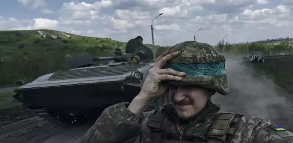 Un soldado ucraniano se agarra el casco mientras viaja a bordo de un APC en Bájmut, en la provincia ucraniana de Donetsk, el 26 de abril de 2023.