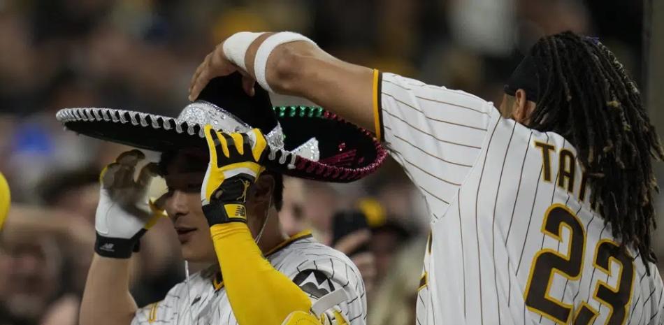 Fernando Tatis Jr. (23) pone un sombrero a Ha-Seong Kim, de los Padres, después de que Kim pegara un jonrón de tres carreras contra los Rojos de Cincinnati.