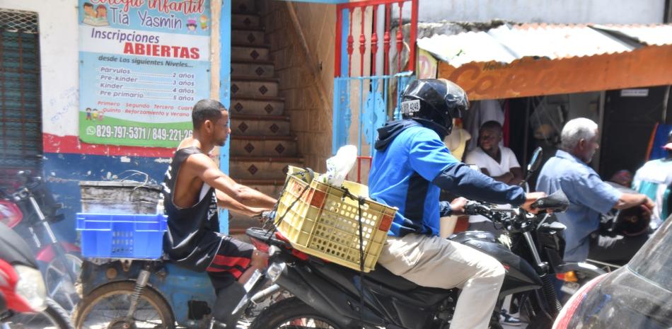 Varios motoristas acarrean pedidos comerciales de los locales del área, que viven en constante asedio y restricciones por los delincuentes que arriban en manadas a saquear sus sitios.