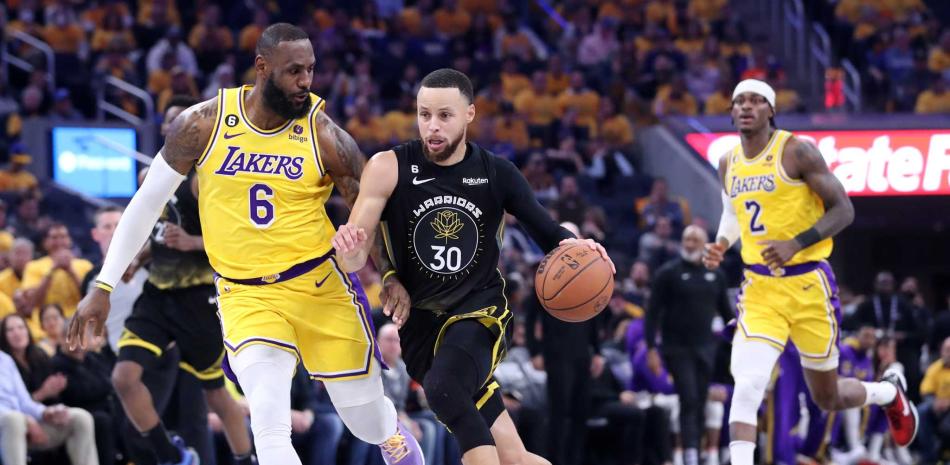 Stephen Curry, de los Warriors, driblea ante la defensa de LeBron James, de los Lakers, en el primer partido de la serie semifinal del Oeste en los playoffs de la NBA.