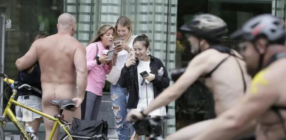 Un ciclista desnudo posa para las fotos mientras otros participantes pasan en bicicleta durante el paseo en bicicleta desnudo de Filadelfia en Filadelfia, el 8 de septiembre de 2018
