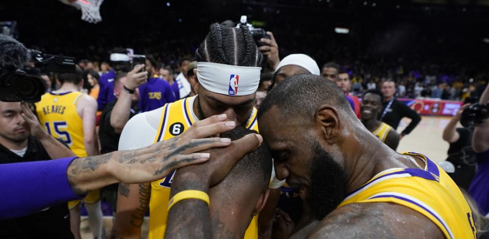 El alero de Los Angeles Lakers, Anthony Davis, a la izquierda, y el alero LeBron James, a la derecha, felicitan al guardia Lonnie Walker IV después de que los Lakers derrotaron a los Golden State Warriors