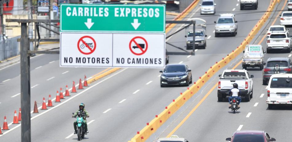 Un agente de la Digesett se pasea por un elevado, mientras que un motorista viola la señal de transito "No motores".