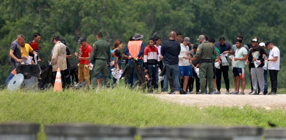 Migrantes caminan hacia donde la Patrulla Fronteriza de los Estados Unidos los procesa después de que cruzaron a los Estados Unidos desde México