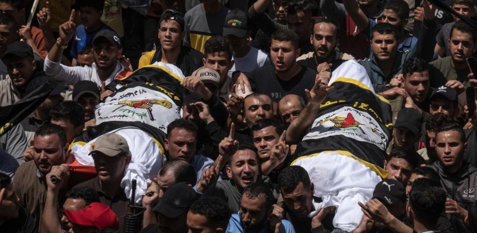 Los palestinos cargan los cuerpos del comandante de la Jihad Islámica Ali Ghali, a la izquierda, y su hermano, Mohammed Ghali, ambos asesinados en un ataque aéreo israelí en Khan Younis, en el sur de la Franja de Gaza, el jueves 11 de mayo de 2023. Ambos están envueltos en la bandera de la Jihad Islámica.