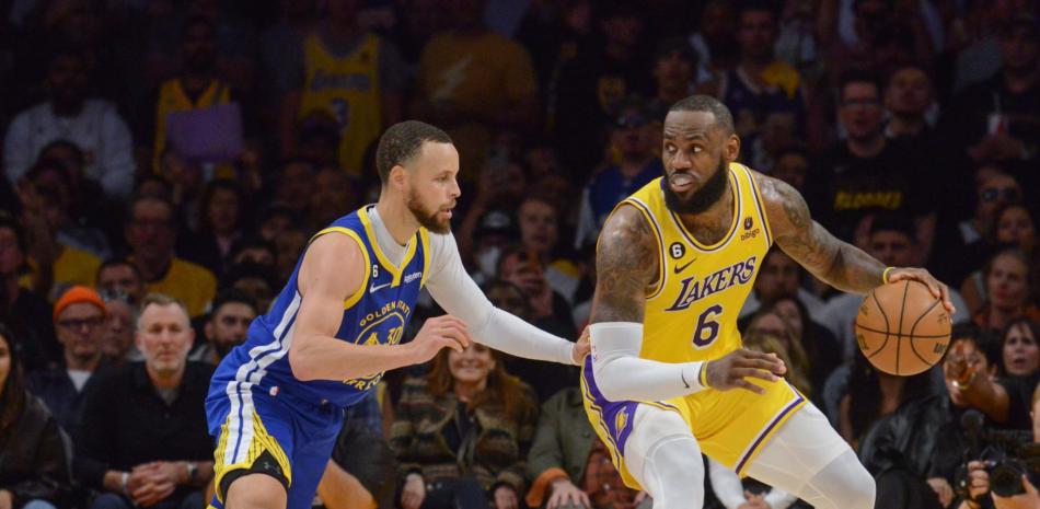 LeBron James, de los Lakers, maneja el balón ante la defensa de Stephen Curry, de los Warriors.