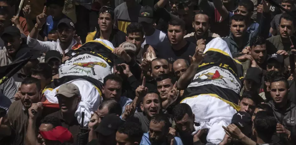 Palestinos cargan los cuerpos del comandante de la Yihad Islámica Ali Ghali, a la izquierda, y su hermano, Mohammed Ghali, ambos asesinados en un ataque aéreo israelí en Khan Younis, al sur de la Franja de Gaza, ayer jueves. Ambos están envueltos en la bandera de la Yihad Islámica.