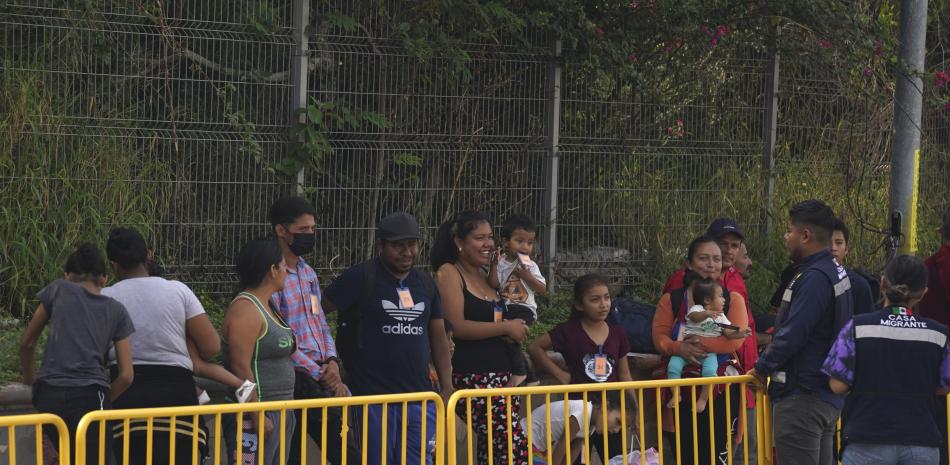 Un grupo de 50 migrantes esperan afuera de una oficina de inmigración mexicana mientras son organizados por la organización Casa Migrante para cruzar la frontera entre Estados Unidos y México desde Matamoros, México.