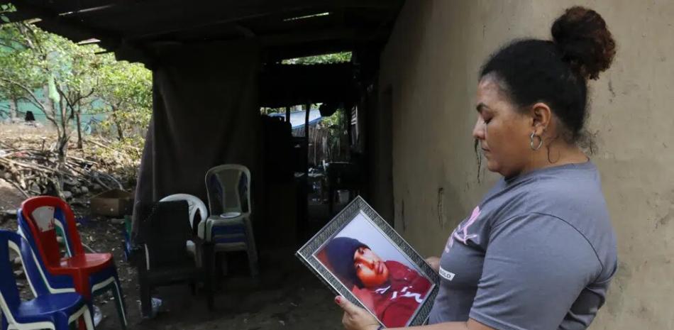 Norma Saraí Espinoza Maradiaga sostiene una fotografía de su hijo, Ángel Eduardo Maradiaga Espinoza, en su hogar en Olanchito, Honduras, el sábado 13 de mayo de 2023.
