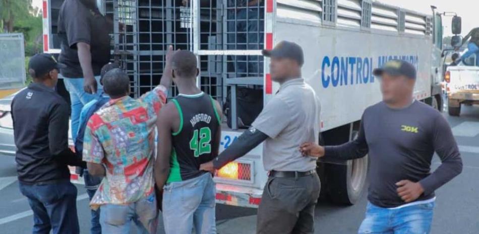 Agentes de la Dirección General de Migración mientras detienen a un grupo de haitianos
