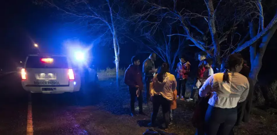 Un agente de inmigración detiene a un grupo de migrantes centroamericanos cuando caminaban en una carretera tras haber cruzado la frontera entre Texas y México, el viernes 12 de mayo de 2023, en Fronton, Texas.