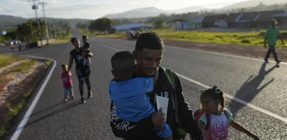 Miguel González y su familia, todos de origen venezolano, caminan en Santa Elena, Venezuela, hacia el transporte que los llevará a la frontera con Brasil, el miércoles 5 de abril de 2023.