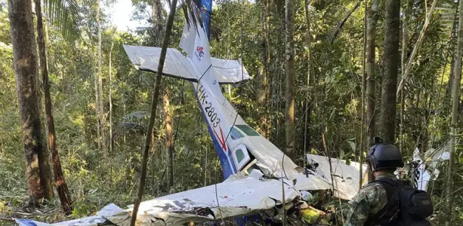 Un soldado permanece frente a los restos de una avioneta Cessna C206 el jueves 18 de mayo de 2023. La aeronave se estrelló en la selva de Solano, Colombia.