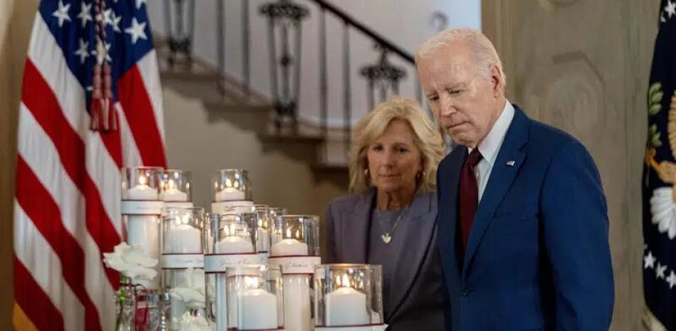 El presidente Joe Biden, acompañado por la primera dama Jill Biden, observa flores y velas con los nombres de las víctimas de la masacre en una escuela primaria de Uvalde, Texas,