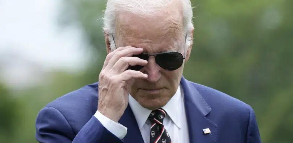 El presidente Joe Biden se retiró los lentes de sol mientras se acerca a hablar con los reporteros después de regresar a la Casa Blanca, el domingo 28 de mayo de 2023
