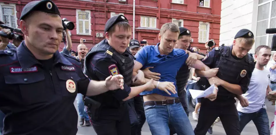 Varios policías detienen al líder opositor ruso Alexei Navalny (centro) en Moscú, Rusia, el 10 de julio de 2013.