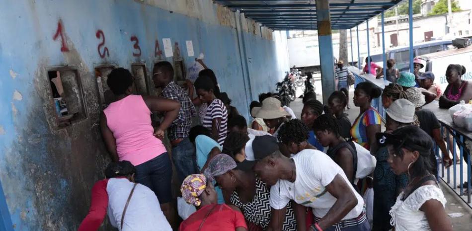 Decenas de personas reunidas frente a la Penitenciaría Nacional de Haití, en el centro de Puerto Príncipe, aguardando su turno para entregar alimentos a sus familiares encarcelados, el jueves 1 de junio de 2023