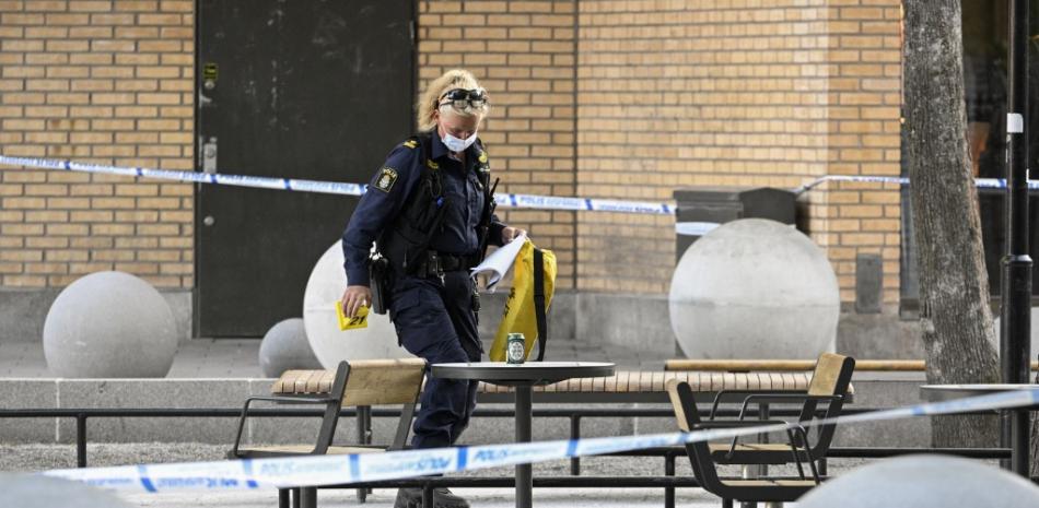 Un oficial forense de la policía trabaja en la escena de un tiroteo en el centro comercial Farsta en el sur de Estocolmo el 10 de junio de 2023.