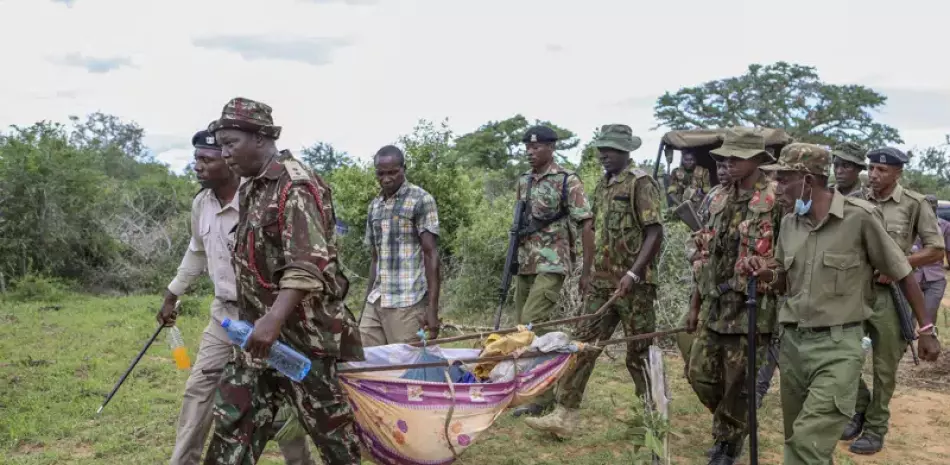 Policías y residentes cargan los cadáveres exhumados de las víctimas de una secta religiosa en la localidad de Shakahola, cerca de la ciudad costera de Malindi, en el sur de Kenia, el 23 de abril de 2023.