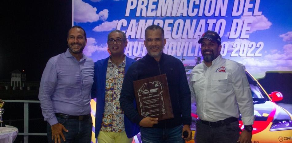 José Lora, presidente del CDCC, Véctor Montes de Oca, secretario del CDCC y Arturo Estévez, Ejecutivo de la DRL, junto al momento de reconocer al comunicador Aquiles José Ramírez.