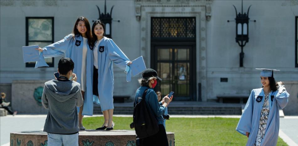 Estudiantes de la Universidad de Columbia posan para fotografías el día de la graduación, el 20 de mayo de 2020, en Nueva York.