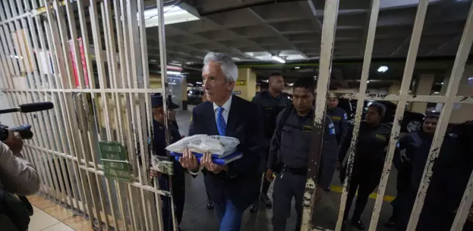 El periodista José Rubén Zamora, con esposas, es escoltado por la policía hacia la corte para una audiencia relacionada con su juicio por presunto lavado de dinero y otros cargos en Ciudad de Guatemala.