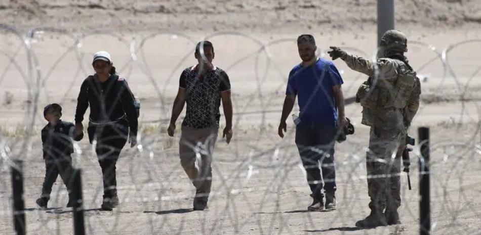 Migrantes esperan a las autoridades estadounidenses en la frontera entre EEUU y México, visto desde Ciudad Juárez, México, el miércoles 10 de mayo de 2023.