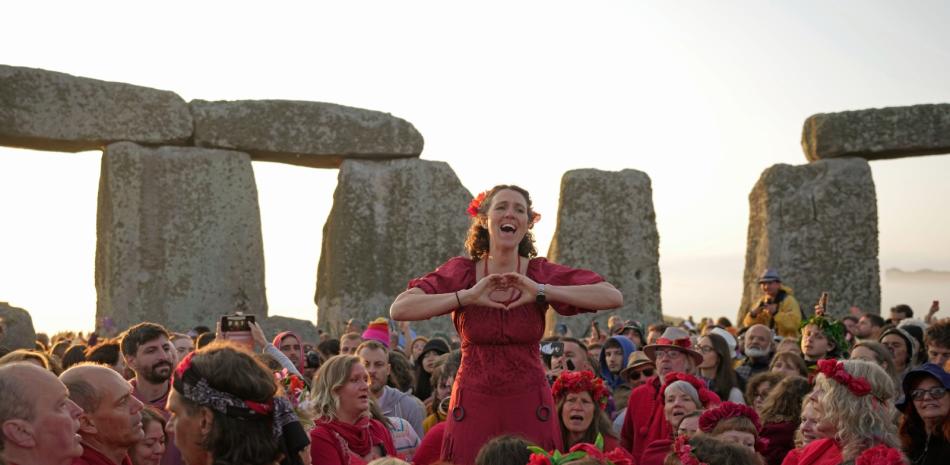 Gente reunida en el antiguo círculo de piedra de Stonehenge para celebrar el Solsticio de Verano, el día más largo del año, cerca de Salisbury, Inglaterra, el miércoles 21 de junio de 2023. (AP Foto/Kin Cheung)