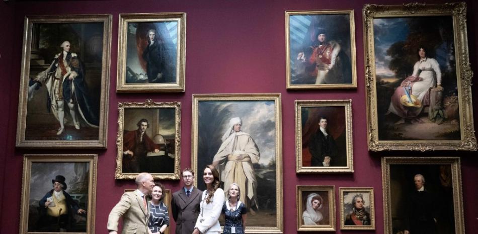 Catherine, princesa de Gales (4L), de Gran Bretaña, reacciona cuando se le muestra una galería que incluye obras de arte de Joshua Reynolds, incluida su pintura titulada "Retrato de Mai (Omai)" (C), mientras asiste a la reapertura de la Galería Nacional de Retratos, en Londres el 20 de junio de 2023, luego de un extenso programa de renovación de tres años.