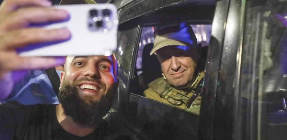 Yevgeny Prigozhin, propietario de la compañía militar Wagner Group, a la derecha, se sienta dentro de un vehículo militar y posa para una selfie con un civil local en una calle de Rostov-on-Don, Rusia, el sábado 24 de junio de 2023, antes de partir.