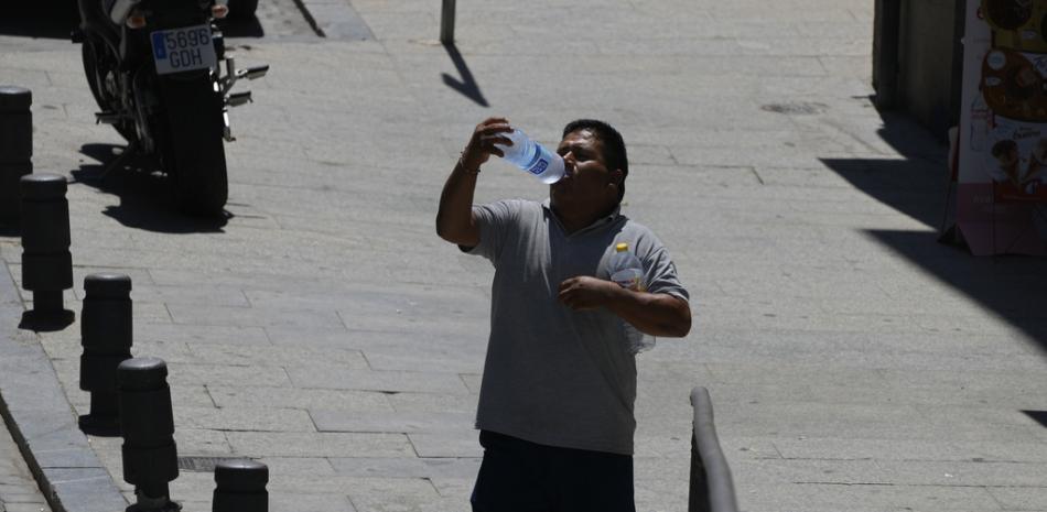 Un hombre bebe de una botella de agua en Madrid