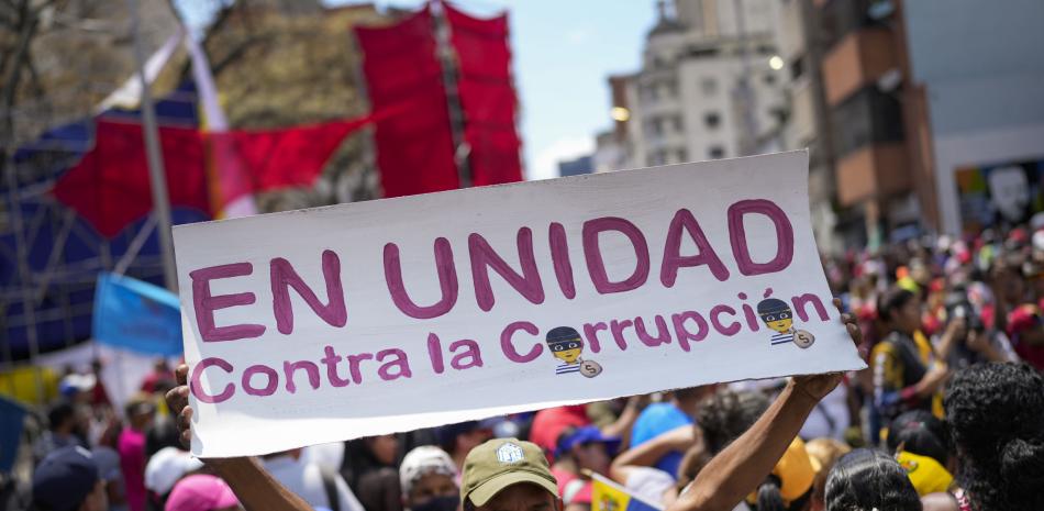 Un simpatizante gubernamental sostiene un letrero durante una marcha contra la corrupción, el sábado 25 de marzo de 2023, en Caracas, Venezuela.