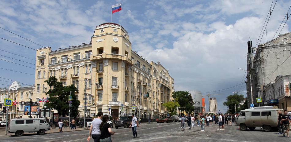 La gente camina por una calle mientras los miembros del grupo Wagner patrullan un área en el centro de Rostov-on-Don, el 24 de junio de 2023.