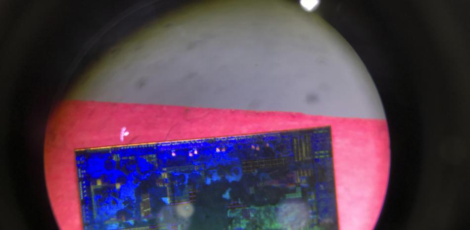 En esta imagen de archivo, un microchip chino visto a través de un microscopio en el puesto del proyecto estatal Tsinghua Unigroup, que busca controlar la industria de los semiconductores china, durante la 21ra edición de la Exposición Internacional de Alta Tecnología, en Beijing, China, el 17 de mayo de 2018.