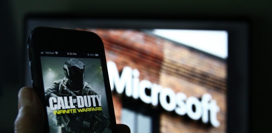 Una imagen de Call of Duty de Activision se muestra en un smartphone cerca de una fotografía del logotipo de Microsoft en esta foto tomada en Nueva York, el jueves 15 de junio de 2023