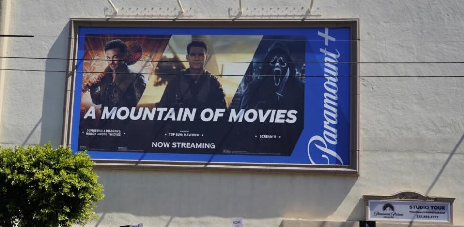 Un anuncio del servicio de transmisión Paramount+ aparece arriba de escritores y actores en huelga en un mitin frente a los estudios Paramount en Los Ángeles el viernes 14 de julio de 2023.