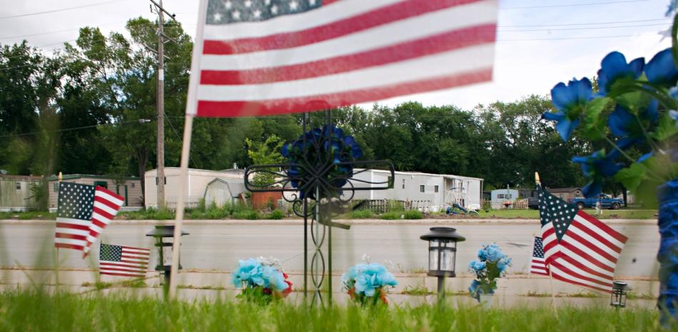 Flores y banderas fueron colocadas en el lugar donde un policía murió y dos resultaron heridos cuando atendían un reporte de un accidente de tránsito, en Fargo, Dakota del Norte.