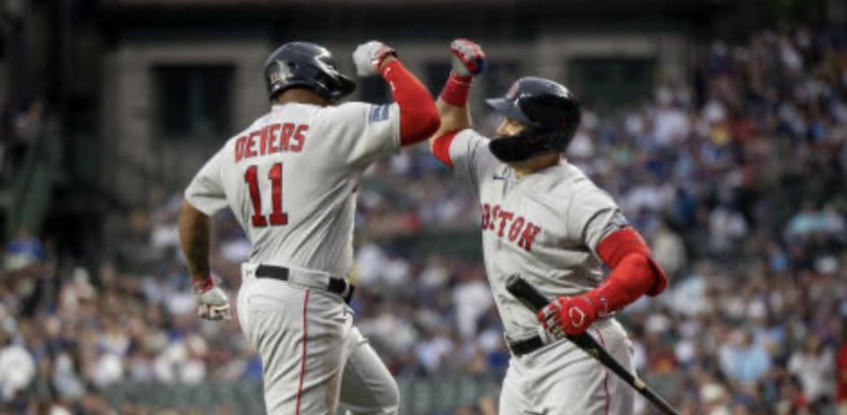 Rafael Devers es felicitado por un compañero tras dar su jonrón este domingo.