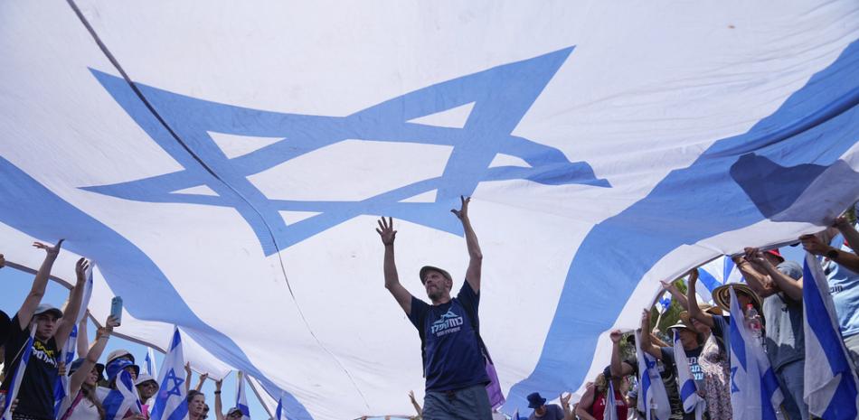 Los manifestantes ondean una gran bandera israelí