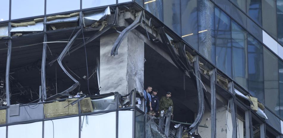 Investigadores examinan los daños causados a un rascacielos por un ataque con dron en el distrito financiero Ciudad de Moscú,