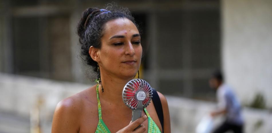 Una mujer se refresca con un ventilador eléctrico durante un día de calor sofocante en Beirut