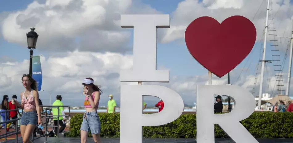Turistas caminan por el área de atraque después de salir del crucero Mardi Gras de Carnival en la bahía de San Juan, Puerto Rico, el 3 de agosto de 2021, marcando la primera vez que un crucero visita territorio estadounidense desde que comenzó la pandemia de COVID-19.