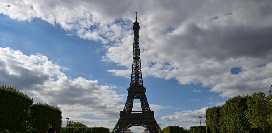 Turistas y parisinos se sientan en el Campo de Marte frente a la Torre Eiffel en París el 9 de agosto de 2023.