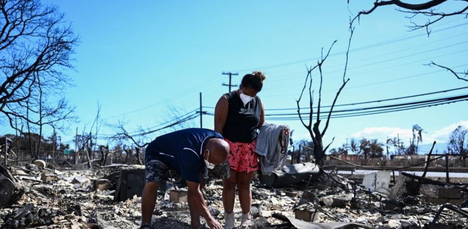 Davilynn Severson y Hano Ganer buscan pertenencias entre las cenizas de la casa de su familia después de un incendio forestal en Lahaina, en el oeste de Maui, Hawái, el 11 de agosto de 2023. Un incendio forestal que dejó a Lahaina en ruinas carbonizadas ha matado al menos a 80 personas.