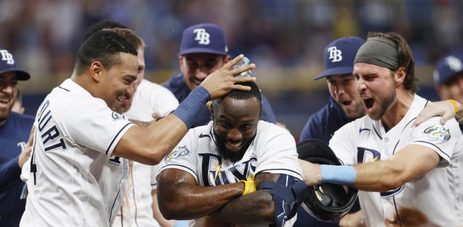 Randy Arozarena es felicitado por sus compañeros tras dispara el hit del triunfo ante Cleveland.