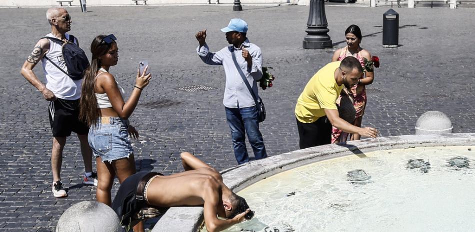 Los turistas se refrescan en una fuente en la Piazza del Popolo de Roma