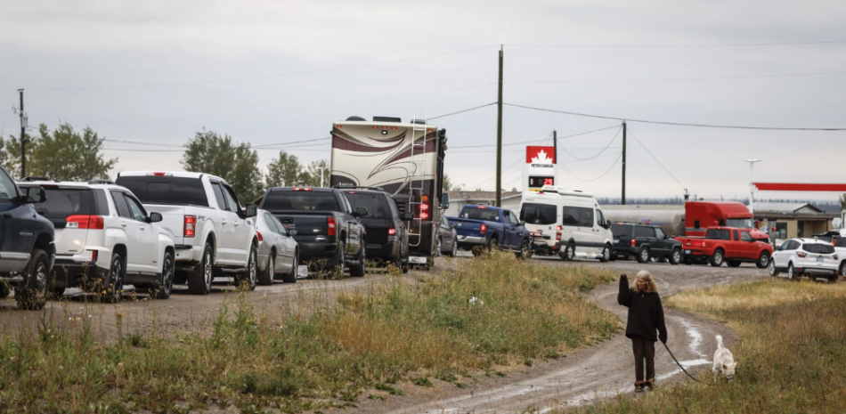 Varios vehículos esperan en fila para repostar, en Fort Providence, en los Territorios del Noroeste, Canadá, en la única carretera hacia el sur desde Yellowknife