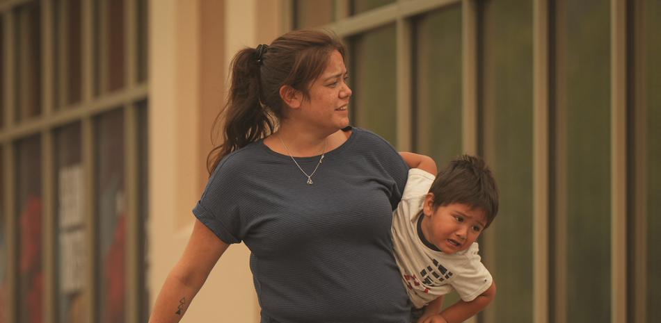 Una mujer lleva a un niño fuera de un centro de evacuación