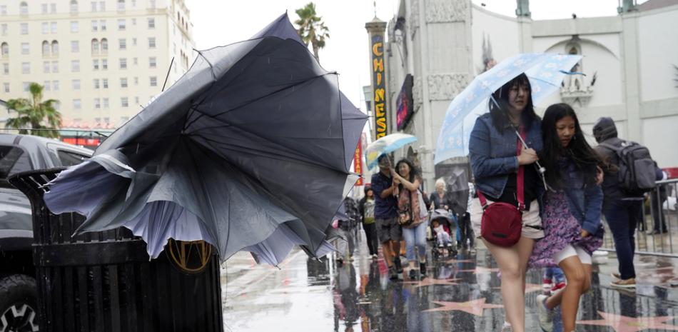 peatones caminan por Hollywood Boulevard durante la tormenta tropical Hilary,